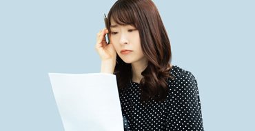 書類を見て考える女性