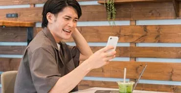 スマホを見て困った表情をする男性