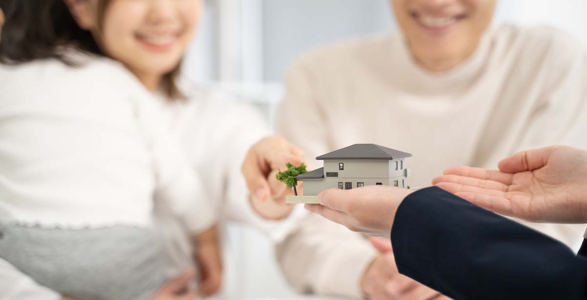 家の模型を持った営業と説明を聞く夫婦