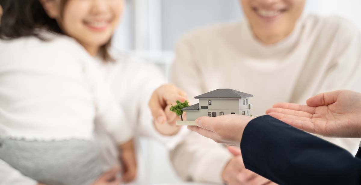家の模型を持った営業と説明を聞く夫婦