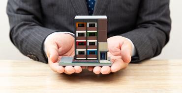 マンションの模型を持つ会社員