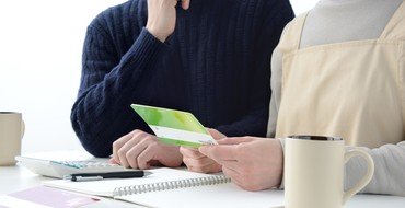 通帳を確かめながら家計を話し合う夫婦