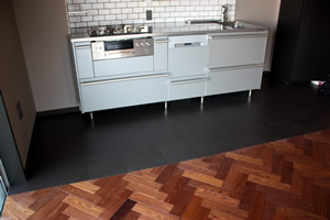 キッチンの床には、高価な大理石や石を使わずに、床材との相性もいいブラックコルクを使用し、スタイリッシュかつコストダウンに成功