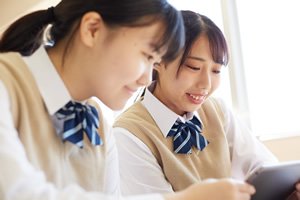 2人の女子学生が教科書を読んでいる画像