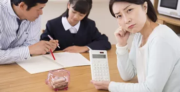 ノートを見ている男性と子供と電卓を持っている女性の画像