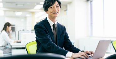 スーツの男性がPCを使っている画像