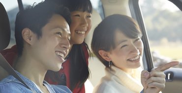 男性と女性と子供が車に乗っている画像