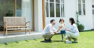 庭で親子がしゃがんでいる画像