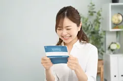 笑顔で通帳を見る女性