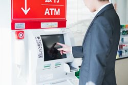 ATMを操作している男性の画像