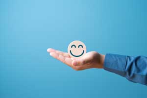 手のひらにスマイルマークが乗っている画像